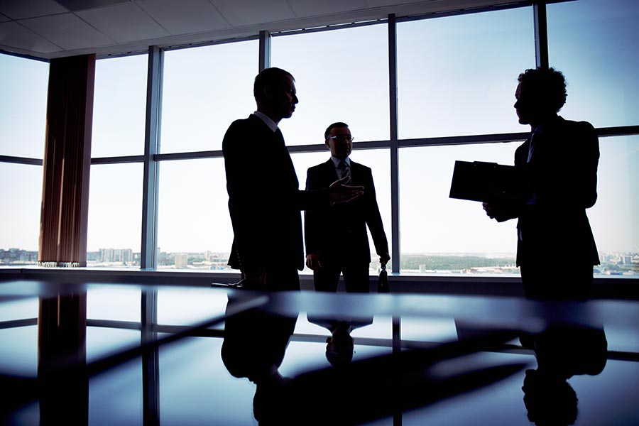 Business Insurance - Silhouette of Business Partners in a Conference Room In a High Building